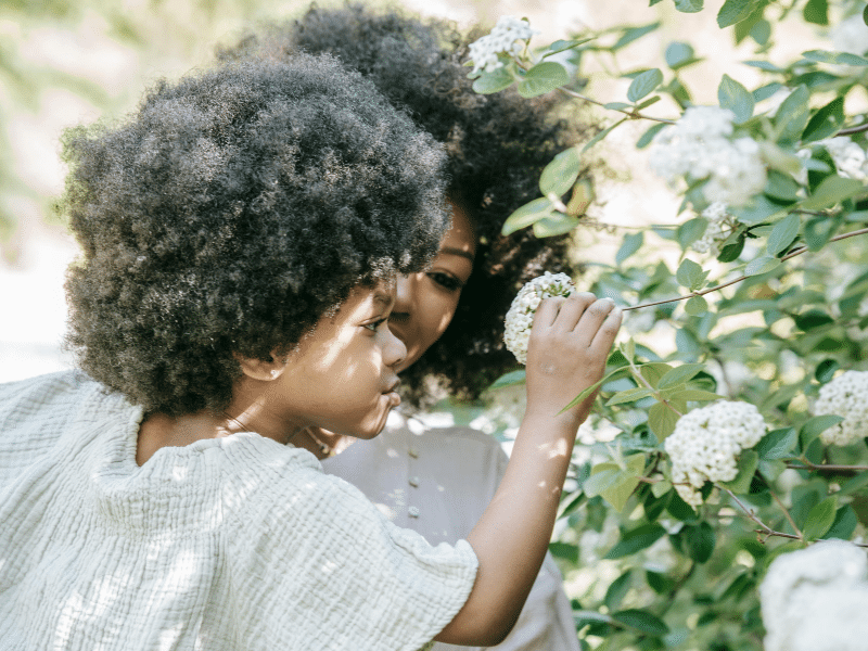 petite fille qui sent une fleur