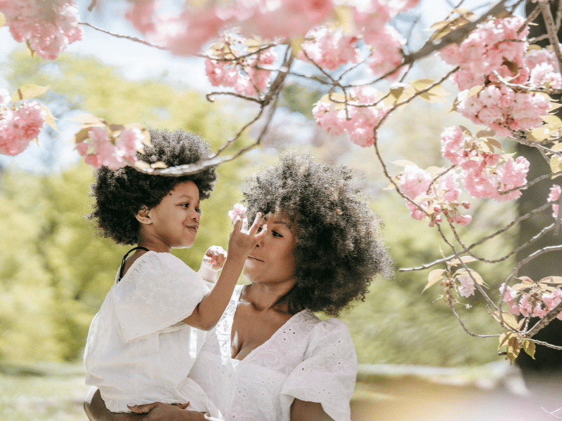 petite fille qui touche une fleur